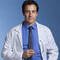 A confident male doctor in a white lab coat and blue shirt, smiling against a blue background.