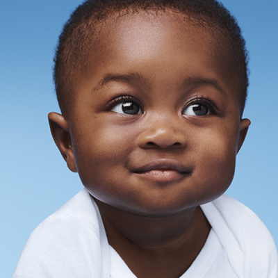 Young baby wearing a nappy smiling and playing