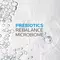Text on a light, water-like background reads: "Prebiotics Rebalance Microbiome," with "Prebiotics" in bold blue letters and the other text in black.