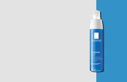 A blue bottle of skincare product with a white pump top, positioned against a light gray and blue background.