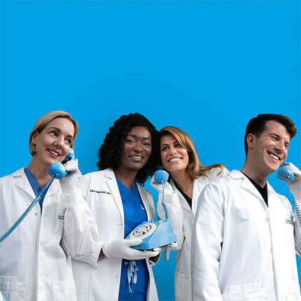 A diverse group of five healthcare professionals wearing lab coats and holding vintage blue phones, smiling and engaged in conversation against a bright blue background.
