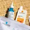 A close-up of two skincare products from La Roche-Posay: a blue serum labeled "HYALU B5" and a sunscreen labeled "ANTHELIOS 50+" displayed on a woven surface.