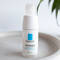 A white skincare bottle of La Roche-Posay's Toleriane Ultra Contour Yeux, featuring a simple blue logo on the front.