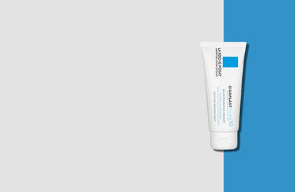 A white tube of skincare cream with a blue label, positioned against a light gray and blue background.