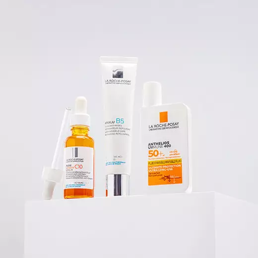 Vitamin C 10 Serum, Hyalu B5 Cream and Anthelios UVMune 400 SPF 50+ standing against a bright white background and on a reflective surface