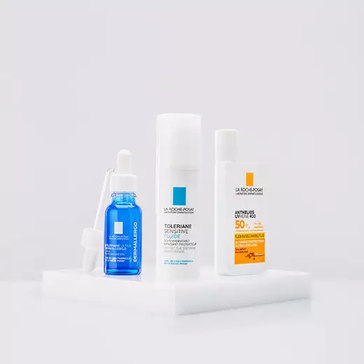 Niacinamide Serum, Toleriane Dermallergo Cream and Anthelio Pigment Correct standing against a bright white background and on a reflective surface