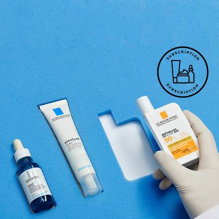 A hand wearing a glove holds a sunscreen bottle alongside a tube and a dropper bottle of skincare products, set against a bright blue background. A subscription icon is in the upper right corner.