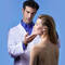 A healthcare professional examines a woman's face, both appearing focused and engaged, against a blue background. The woman has her eyes closed and looks serene.