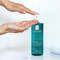 A hand holding a drop of liquid above a bottle of La Roche-Posay Effaclar Micro-Peeling Gel.