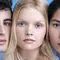 A close-up portrait of three individuals with various features, arranged side by side against a light blue background. They have neutral expressions and are looking directly at the camera, showcasing their diverse appearances.