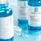 Close-up of La Roche-Posay Hyalu B5 serum bottles on a softly blurred background, showcasing skincare products with labels highlighting anti-wrinkle and repairing properties.
