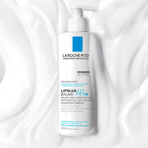 A tube of La Roche-Posay Lipikar AP+M balm, featuring a blue logo and text in French. The product is designed for repairing and soothing atopic skin.