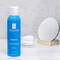 A blue bottle of La Roche-Posay Serozinc, a zinc sulfate solution for oily, blemish-prone skin, is displayed next to a small mirror and cotton pads on a light surface.