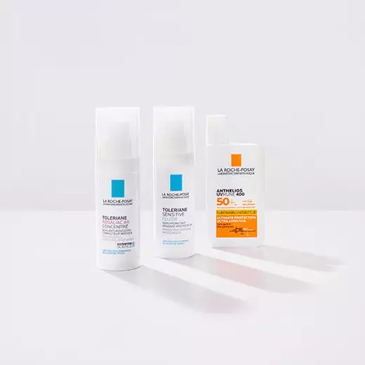 Niacinamide Serum, Toleriane Dermallergo Cream and Anthelio Pigment Correct standing against a bright white background and on a reflective surface