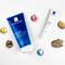 Two skincare products from La Roche-Posay, including a blue tube of Effaclar purifying gel and a white tube of Effaclar cream, surrounded by colorful illustrated elements like balls and pine cones.