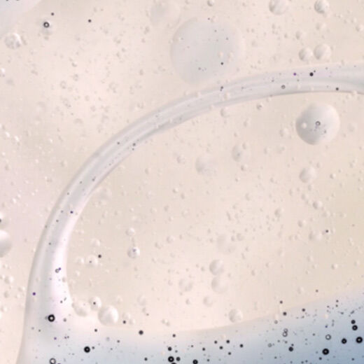 Abstract image of bubbles and liquid, featuring a curved line and a textured surface with varying shades of light.