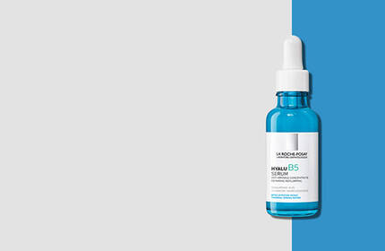 A bottle of bright blue serum with a dropper, set against a split background of gray and blue.