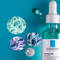 Alt text: A close-up of the La Roche-Posay Effaclar Serum bottle, surrounded by abstract circular designs featuring colorful textures and bubble patterns, all set against a turquoise background.