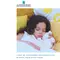 A young child with curly hair peacefully sleeping on a bed surrounded by colorful pillows, holding a stuffed animal.