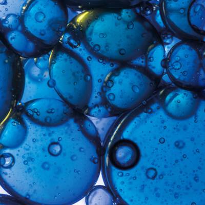 A close up of a skincare ingredient, which is dark blue in colour and bubbly