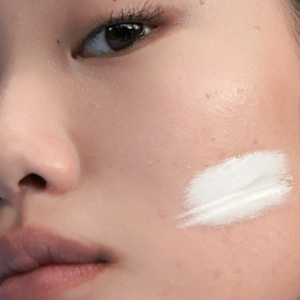 Image of model touching her face with refreshed, supple skin 