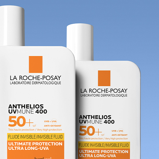 Two bottles of Anthelios UVMUNE 400 Invisible Fluid SPF50+, with one positioned slightly behind the other against a blue background.